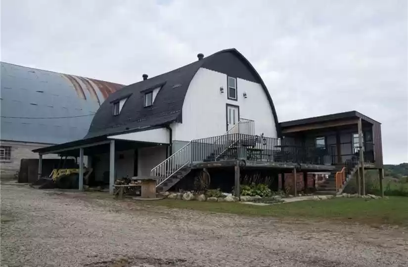 Barn which includes 3-car garage/shop w/9x8 overhead doors, front deck, tiki bar area and a renovated haymow area and loft.  Tons of possibility here!