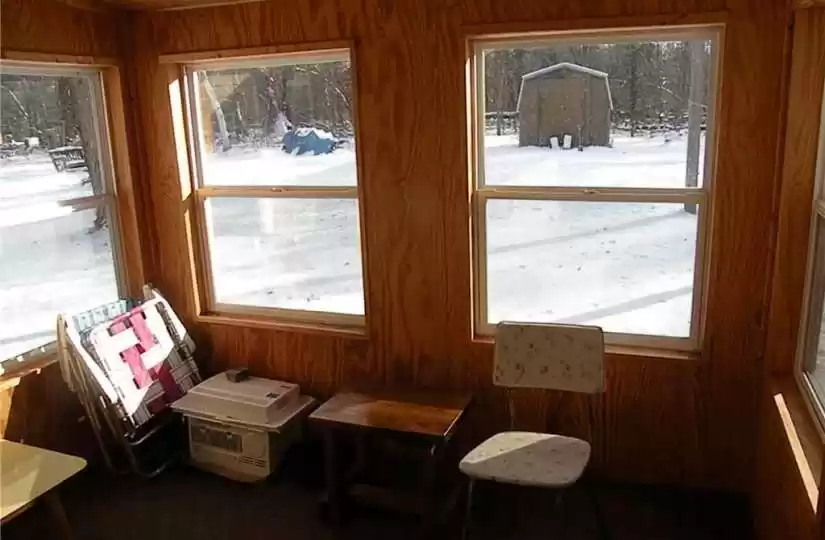 Enclosed porch and view of yard shed